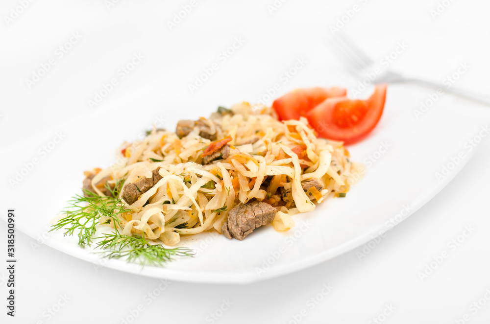 Stewed vegetables with meat: cabbage, onions, carrots and beef on a white plate on a white background Stewed vegetables with meat: cabbage, onions, carrots and beef on a white plate on a white background