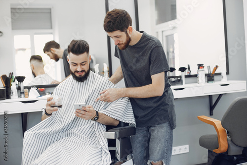 Man with a beard. Hairdresser with a client. Guy drinkig a whiskey photo