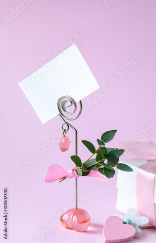 Gift box with a pink bow. Gift for Valentine's Day or March 8th. Business card, holiday card on a pink background. Postcard February 14, Valentine's Day. Vertical photo. Copy space. © Карина Клачук