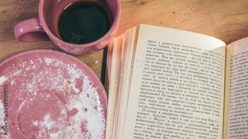 Animation. Coffee gradually disappears in the cup, the pie pieces become smaller until it disappears completely, and pages are scrolling through the book. The video was shot using the Stop Motion