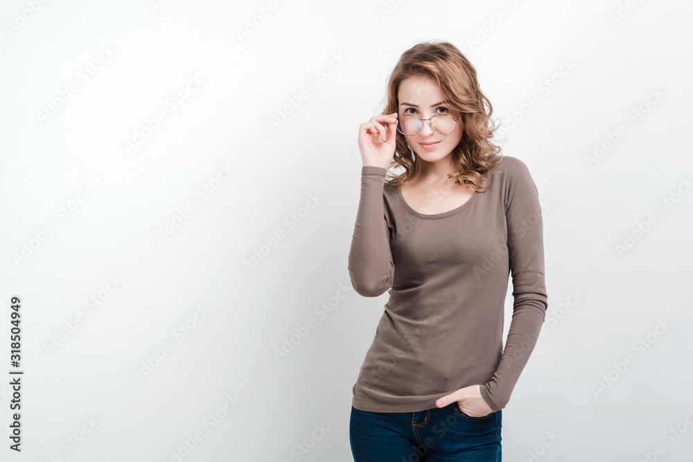 Girl adjusting glasses posing in studio on a white background Girl adjusting glasses posing in studio on a white background