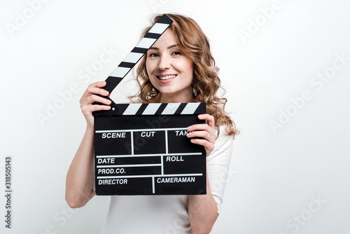 Canvas Print Pretty girl with a movie board on a white background