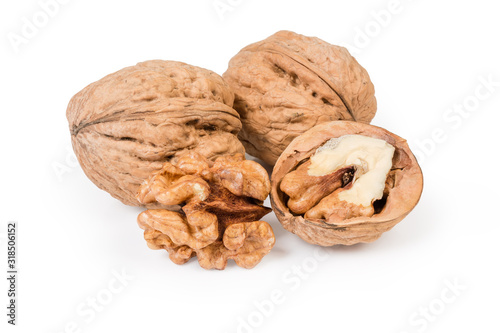 Whole and partly shelled walnuts on a white background