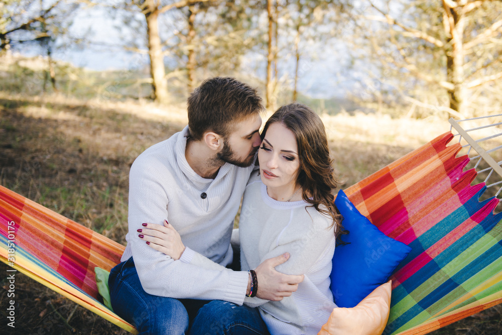 Couple in love, girl and guy in hammock enjoys in the woods, travel love story concept Couple in love, girl and guy in hammock enjoys in the woods, travel love story concept