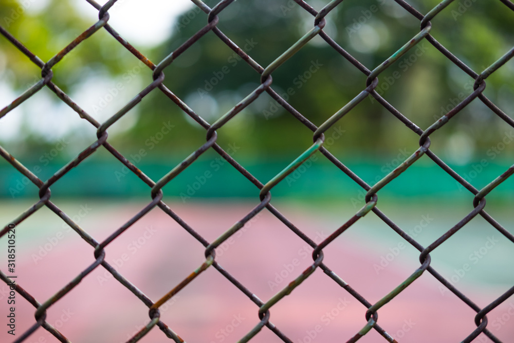 Fototapeta premium Metal fence and tennis court