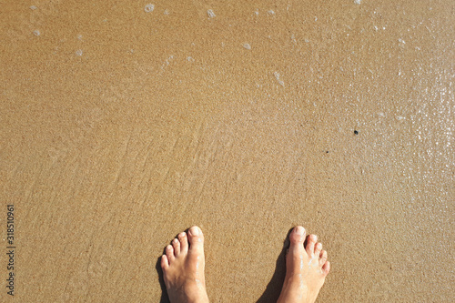 feet on coastal sand by the ocean