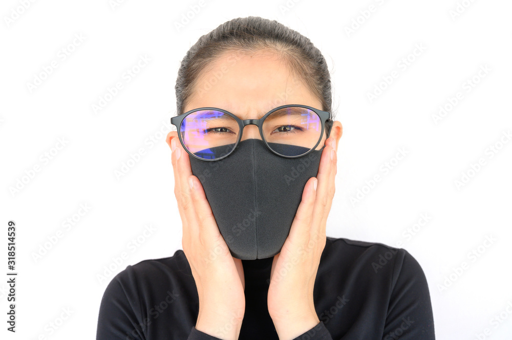 Close up of young Asian woman coughing and wearing black mask for protect bad air pollution. Air pollution has been associated with diseases of the heart and lungs, cancers and other health problems.