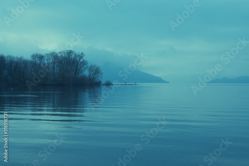 Moody landscape of a lake surrounded by hills and trees