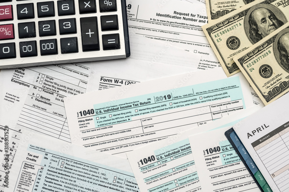 Dollar, calculator and pen with 1040 tax form Dollar, calculator and pen with 1040 tax form