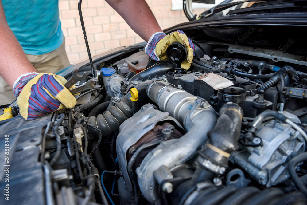 Hands of mechanic's in protective gloves with car engine close up Hands of mechanic's in protective gloves with car engine close up