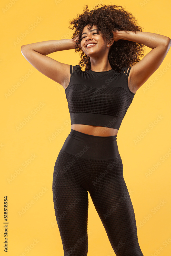Lifestyle Concept. Portrait of beautiful happy and dancing African American woman with curly hair. Yellow studio background. Copy Space. Lifestyle Concept. Portrait of beautiful happy and dancing African American woman with curly hair. Yellow studio background. Copy Space.