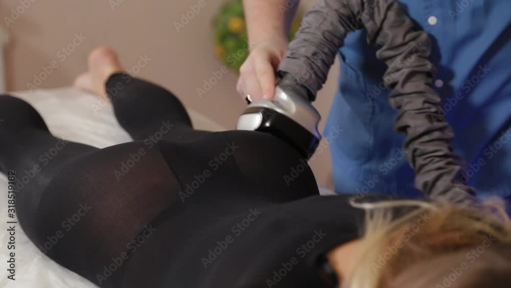 Professional male masseur makes a vacuum massage with a special device to a beautiful woman. Professional male masseur makes a vacuum massage with a special device to a beautiful woman.