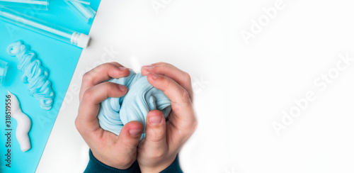 baby holding in hand blue slime and playing, children hobby, child stretches slime, components for making slime