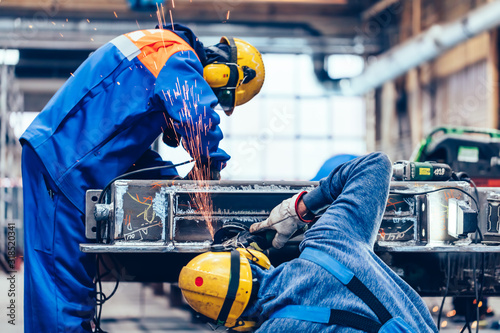 Workers grinding in a workshop. Heavy industry factory