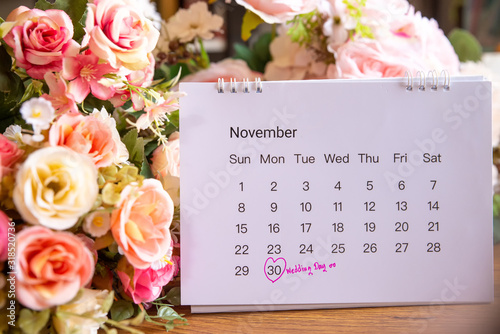 Wedding date anniversary calendar and flower bouquet (rose).Couple of love  planning a honeymoon next month.