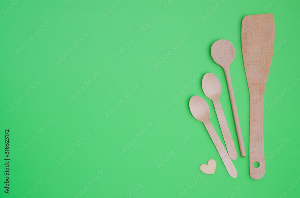 Disposable tableware set from natural materials, wooden spoon, Eco-friendly. Wooden spoons Eco concept on green background. Copy space. Eco pine wood spoons. Disposable tableware set from natural materials, wooden spoon, Eco-friendly. Wooden spoons Eco concept on green background. Copy space. Eco pine wood spoons.