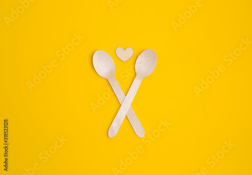Disposable tableware from natural materials, wooden spoon, Eco-friendly. Wooden spoons Eco concept on yellow background. Copy space. Eco pine wood spoons.  © oksanatukane