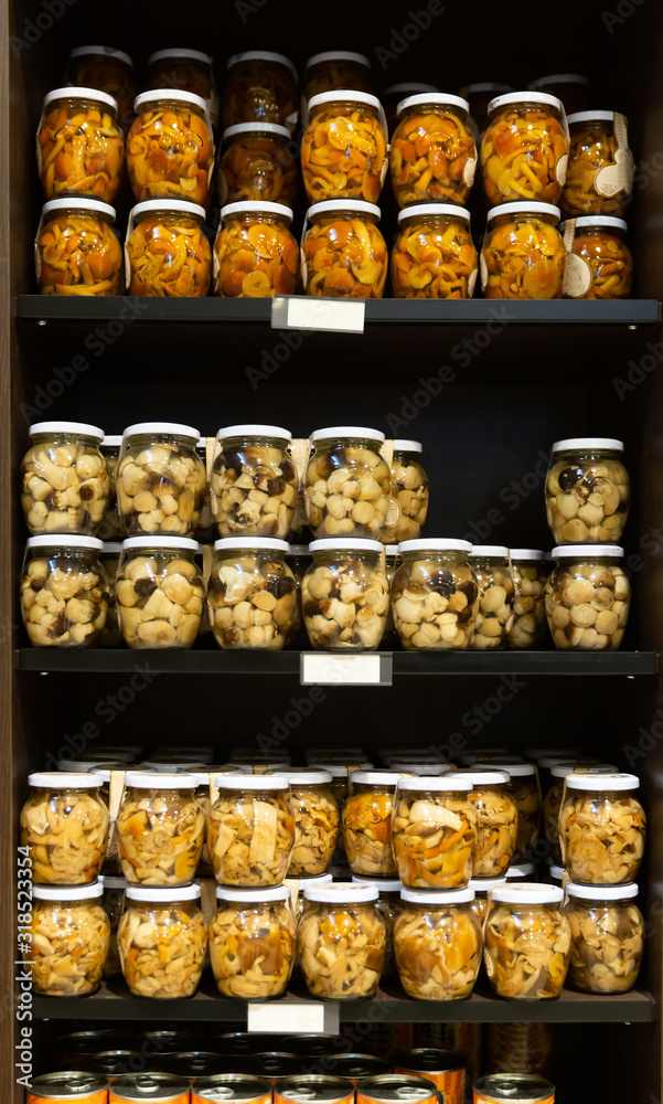 Pickled mushrooms in glass jars in shop