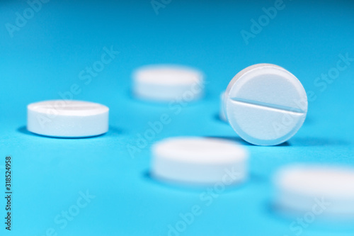 white tablets close-up on a blue background. selective focus. concept of medicine photo