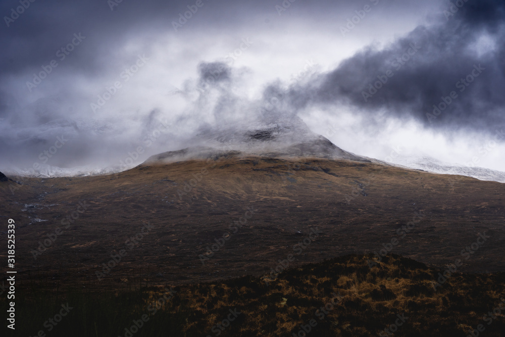 Peak of the mountain hidden in moody clouds Peak of the mountain hidden in moody clouds