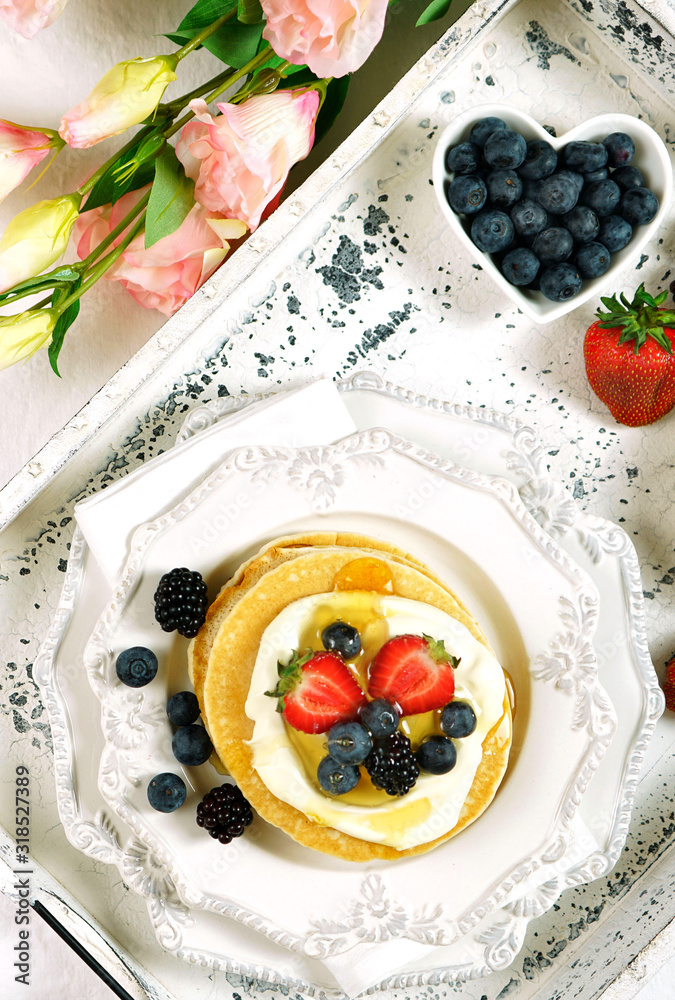 Pancake breakfast tray on table with syrup and blueberries fruit creative layout flat lay top view. Close up vertical. Pancake breakfast tray on table with syrup and blueberries fruit creative layout flat lay top view. Close up vertical.