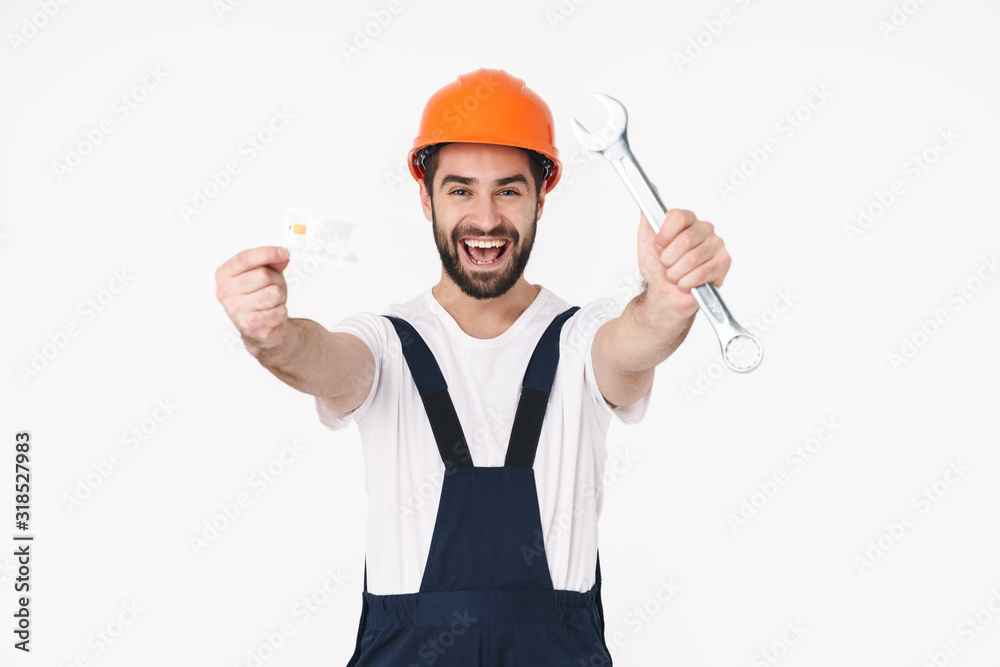 Happy young man holding credit card and wrench. Happy young man holding credit card and wrench.