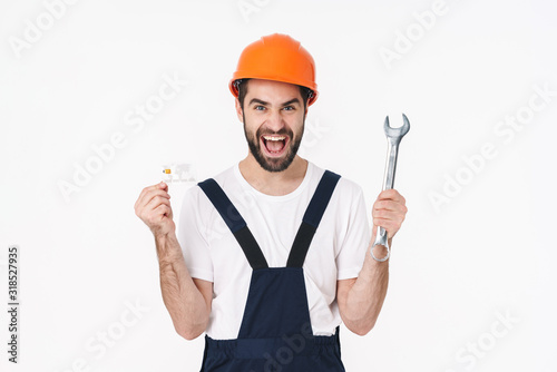 Happy young man holding credit card and wrench.