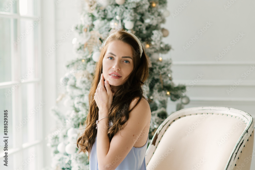 Portrait of an attractive young girl on the background of a Christmas tree Portrait of an attractive young girl on the background of a Christmas tree