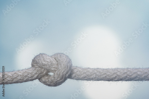 Sailor knot and rope in front of bright blue background 