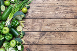Frame Fresh green vegetables and herbs on a wooden background. Copy space.