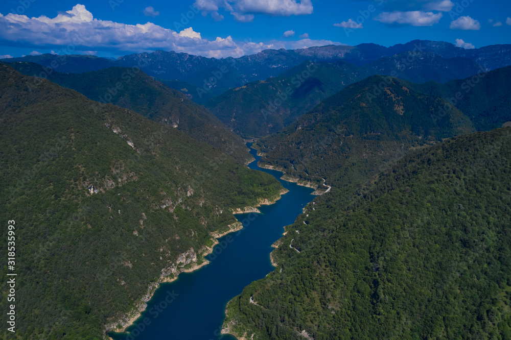 Aerial view, Lake Valvestino, Italy. Beautiful lake between the mountains. Cumulus clouds, blue sky