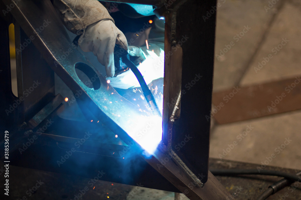 Metal workers use manual labor, Skilled welder, Factory workers making OT. Welder is welding the steel in the factory. Metal workers use manual labor, Skilled welder, Factory workers making OT. Welder is welding the steel in the factory.