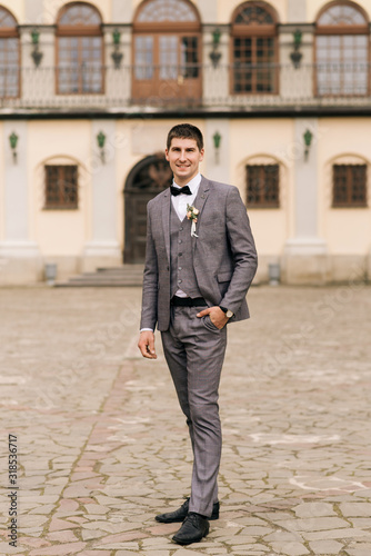 Portrait of the groom on the background of an old building