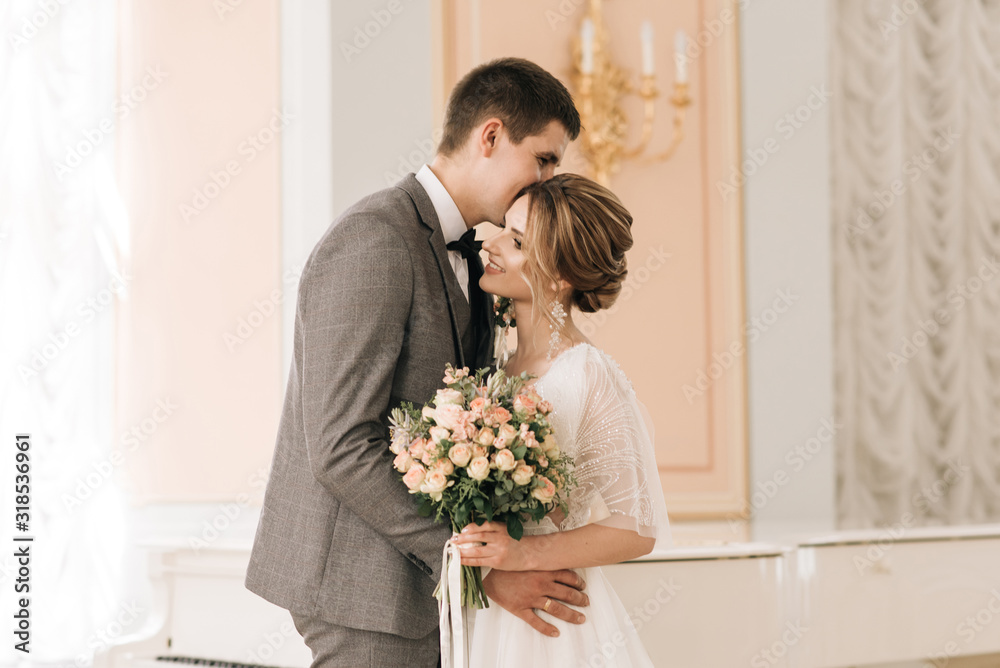 Beautiful elegant couple of newlyweds in love in a luxurious interior Beautiful elegant couple of newlyweds in love in a luxurious interior