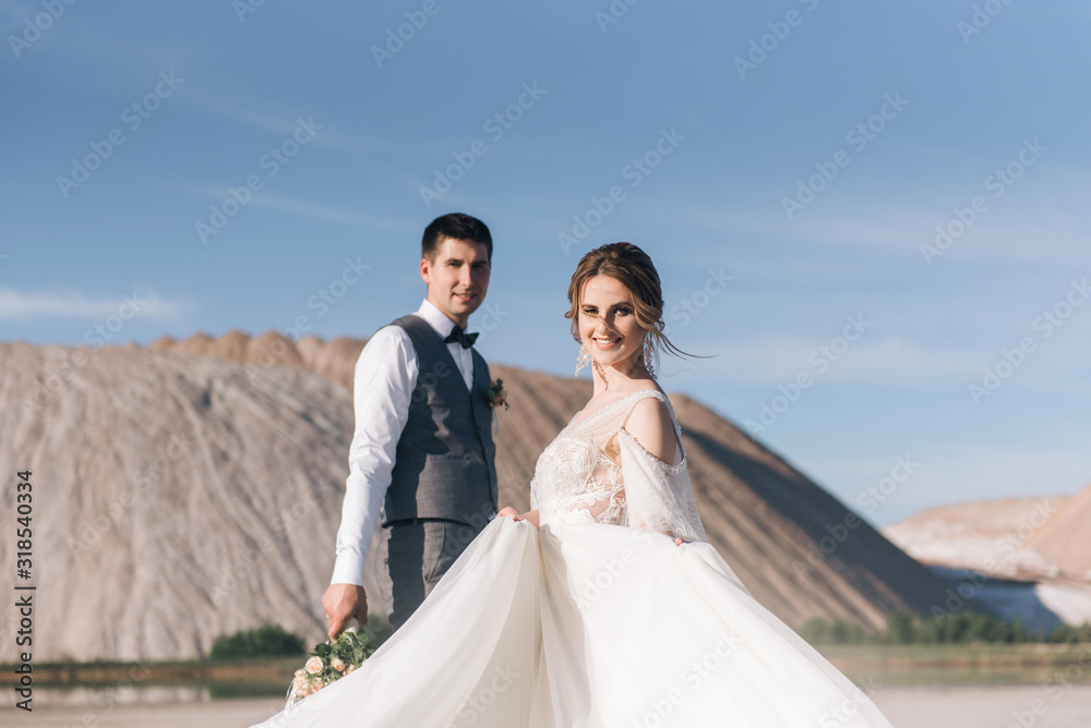 Beautiful elegant couple of newlyweds in love on a beautiful natural background of salt mountains and quarries Beautiful elegant couple of newlyweds in love on a beautiful natural background of salt mountains and quarries
