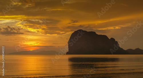 view seaside evening of mountain on the beach with orange and red sun light in cloudy sky background  sunset at Pak Meng Beach  Trang Province  southern of Thailand.