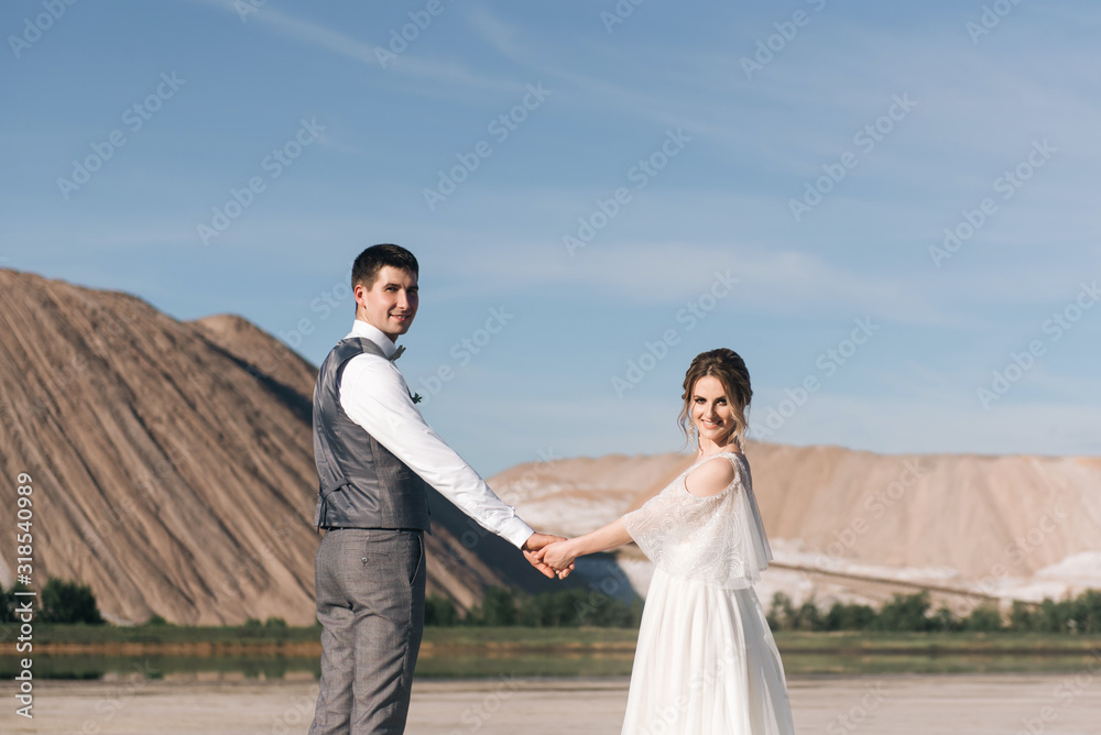 Beautiful elegant couple of newlyweds in love on a beautiful natural background of salt mountains and quarries Beautiful elegant couple of newlyweds in love on a beautiful natural background of salt mountains and quarries