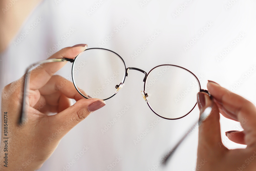 woman hand hand holding eyeglasses closeup ,healthcare and medical concept  - obrazy, fototapety, plakaty 