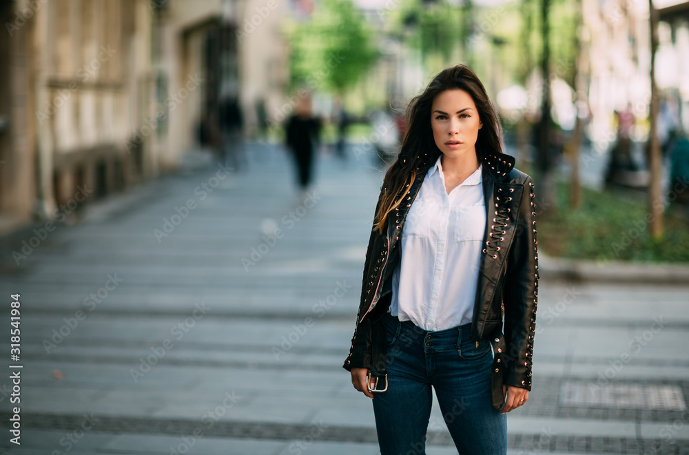 Fototapeta premium Beautiful fashion model in black leather jacket posing outdoor.