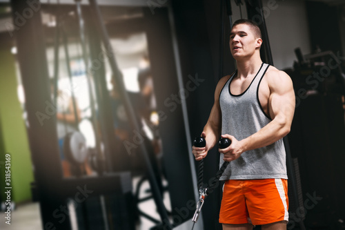 Fit man in sportswear focused on exercise for biceps in the gym