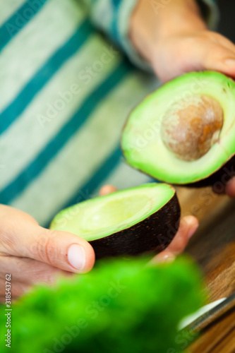 Girl opens a mature avocado in two