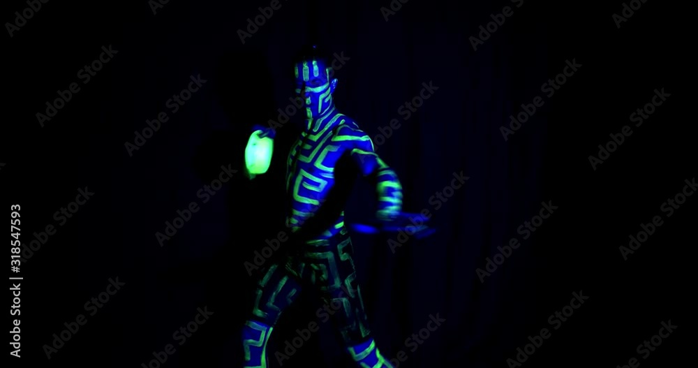 A man with ultraviolet glowing green body art is dancing with a hat, 4k A man with ultraviolet glowing green body art is dancing with a hat, 4k