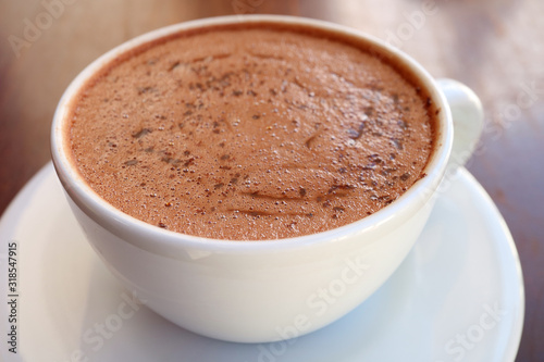 Closeup a cup of mouthwatering hot chocolate on wooden table