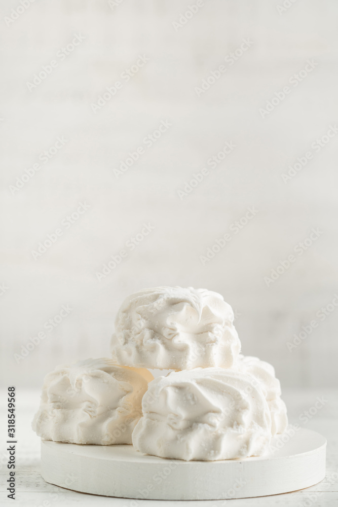 Marshmallow dessert in icing sugar on a light wooden background on a white board Marshmallow dessert in icing sugar on a light wooden background on a white board