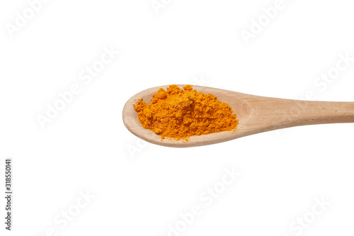 Orange turmeric powder in a wooden spoon on a white background. Natural, useful healing spice from the East. Turmeric
