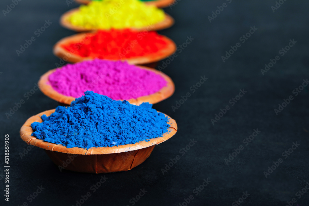 Indian Festival Holi , Colors in wooden bowl on dark background Indian Festival Holi , Colors in wooden bowl on dark background