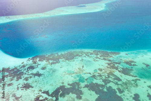 Background image of the turquoise sea. Deep sea and corals. Top view of beautiful Caribbean Sea. Aerial drone shot of turquoise water - space for text. Aquamarine background © icemanphotos