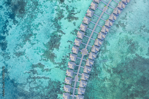 Aerial view of water villas and bungalow, blue sea with tropical lagoon background in Maldives. Luxury summer travel vacation concept, aerial landscape