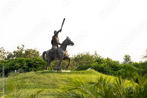 low angle shot of Warrior Bhai Maali Singh statue sitting on horse against trees and sky in the background. historical monument concept.