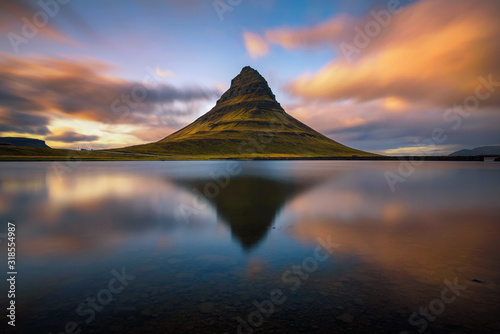 Sunset over Kirkjufell mountain with reflection in a nearby lake in Iceland